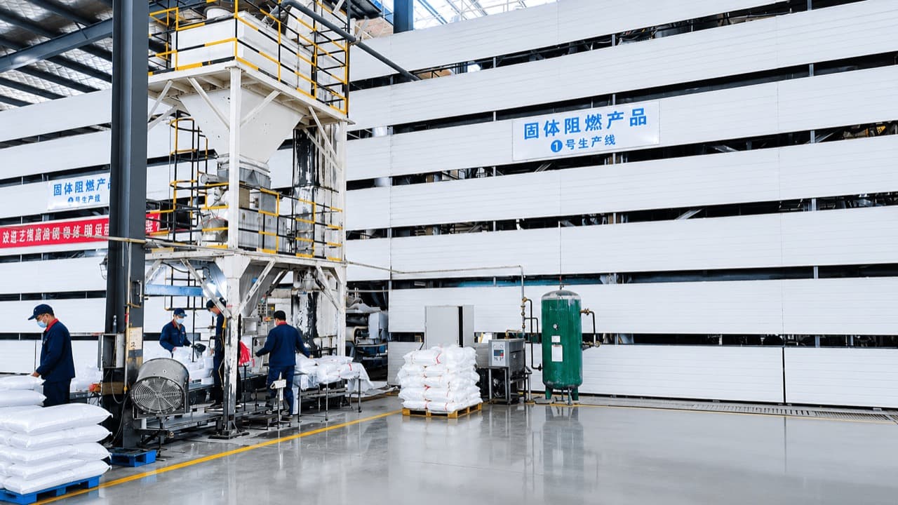 Operators at an automated weighing and bagging station on a finished-product packing line