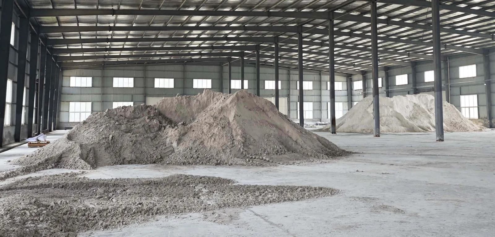 Two separate bulk piles of differing color stored in the raw-material warehouse
